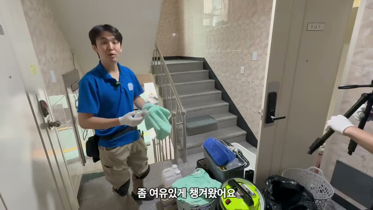 계단에 장비를 펼쳐 놓고 타월을 들어 보이는 장면